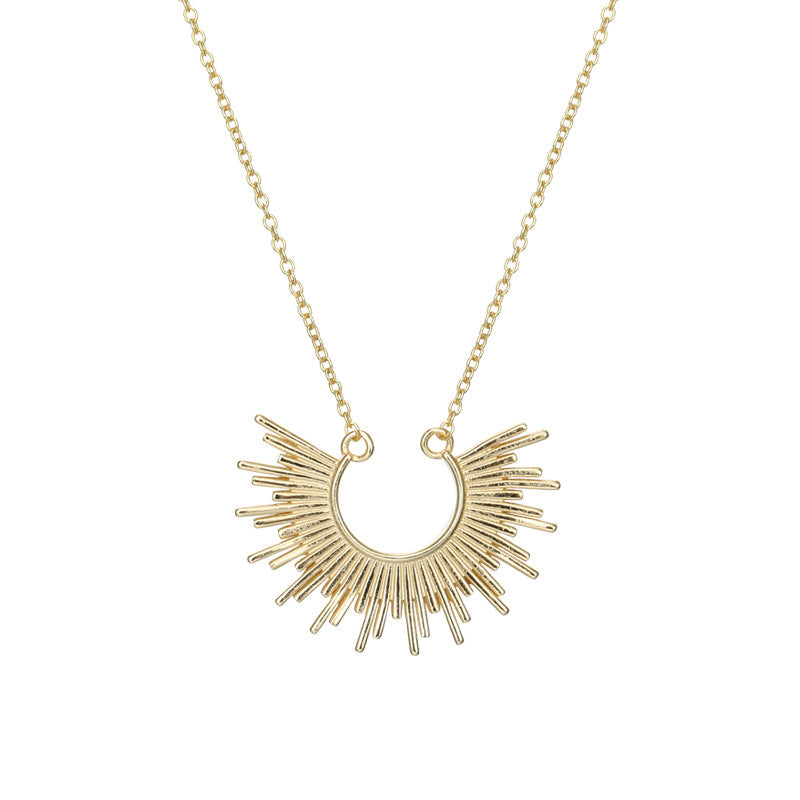 Collier doré avec pendentif soleil stylisé, bijou lumineux pour femme, vue isolée sur fond blanc. Idée cadeau femme ou ado.